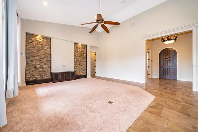 an empty room with ceiling fan and window