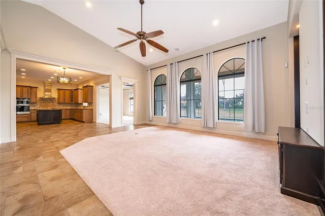 a view of a livingroom with a chandelier fan and windows