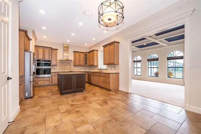 a large white kitchen with a large window and stainless steel appliances