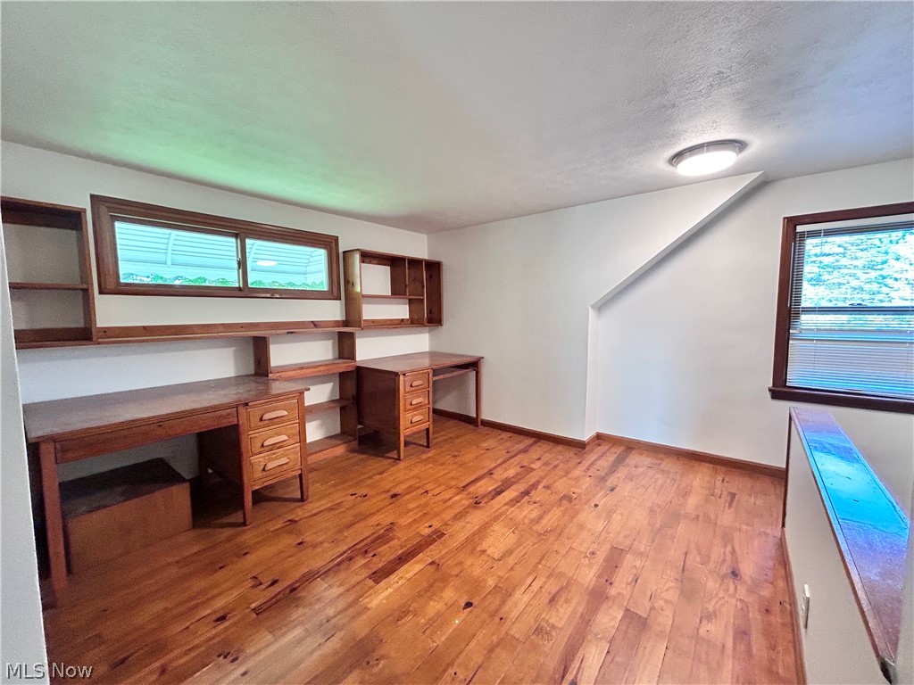 5528 Highland Road Highland Heights, OH 44143 - Photo 10 of 25 Bright upper-level room featuring warm wood-finish flooring, built-in cabinetry and shelving with dual work surfaces and storage drawers, and multiple windows with water views