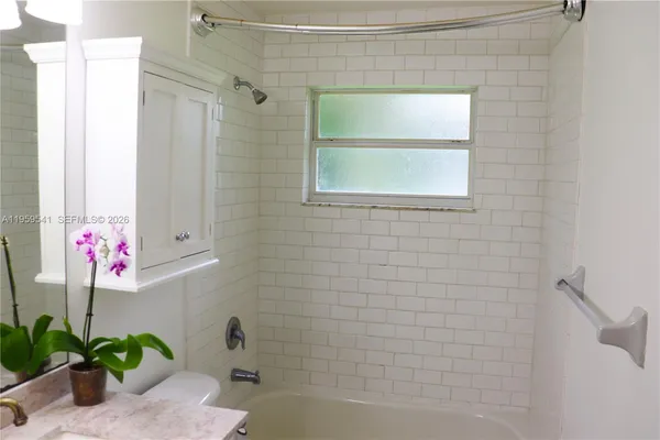 a bathroom with a shower curtain a mirror and a shower