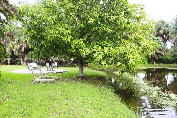 a view of a chairs and table in backyard of the house