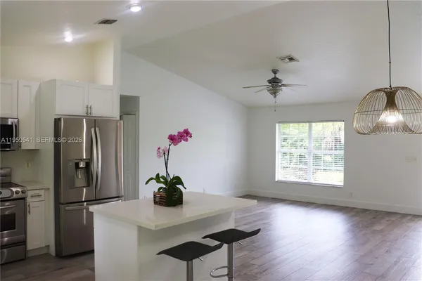 a kitchen with a refrigerator and a stove top oven