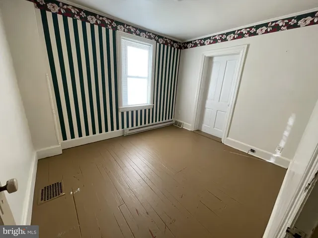 a view of a room with wooden floor and windows