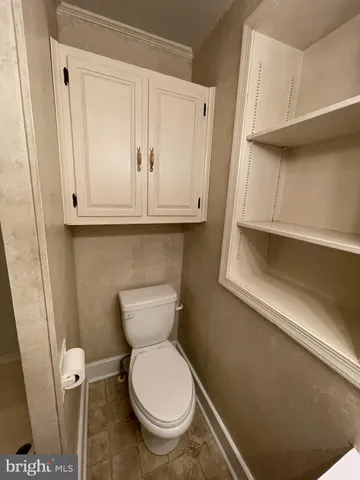 a bathroom with a toilet and a mirror