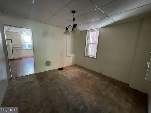 an empty room with windows and cabinet
