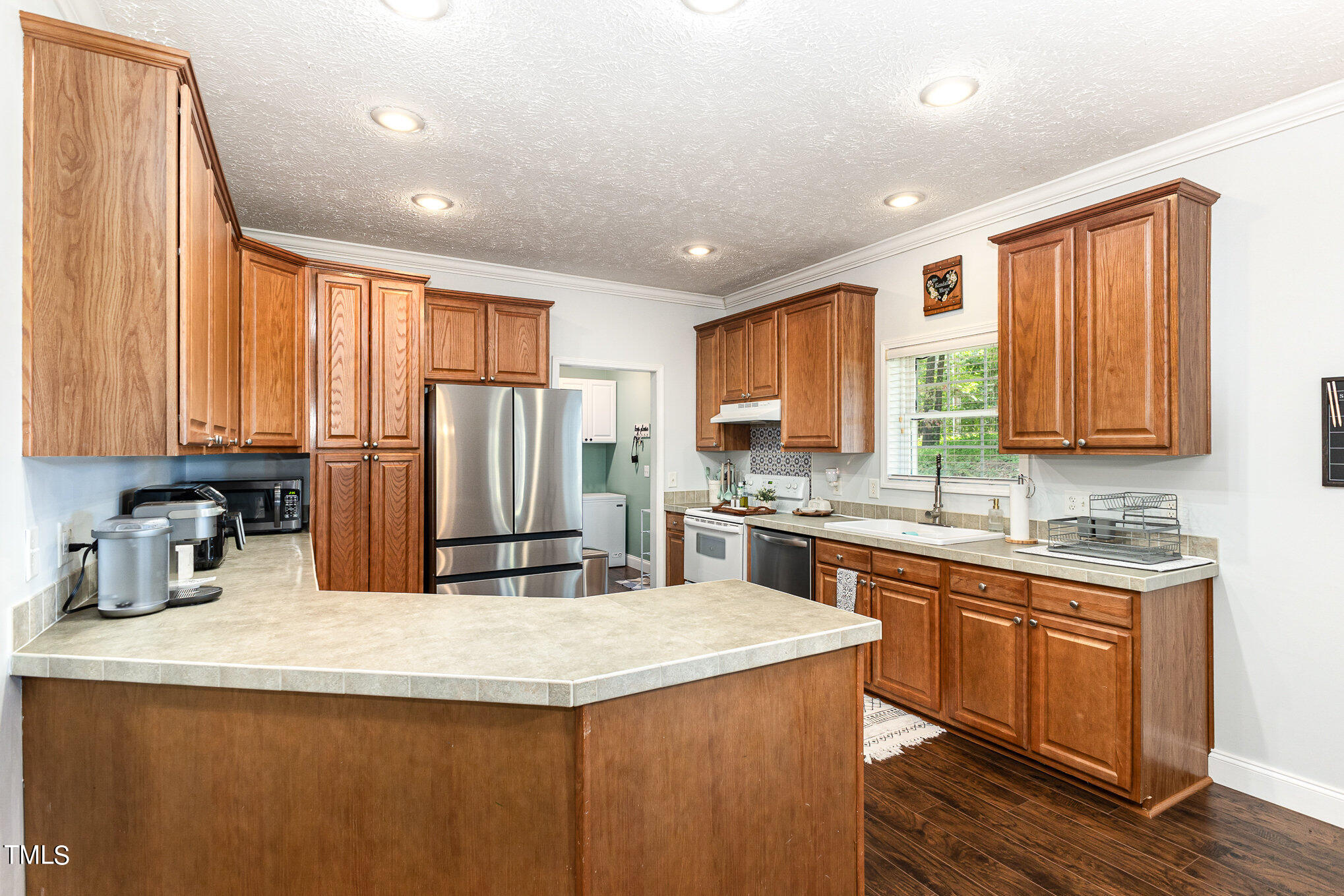 104 Dove Road Creedmoor, NC 27522 - Photo 23 of 25 a kitchen with stainless steel appliances granite countertop refrigerator sink and cabinets
