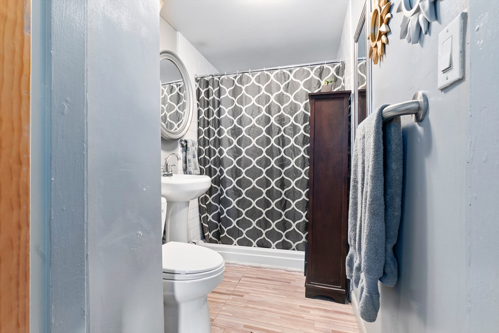 159 Jenness Street Lynn, MA 01904 - Photo 9 of 36 a bathroom with a toilet and a shower curtain