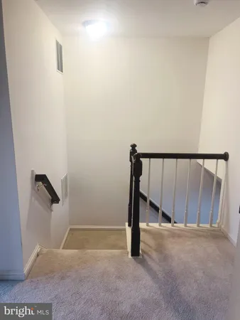 an empty room with wooden floor and windows with curtains