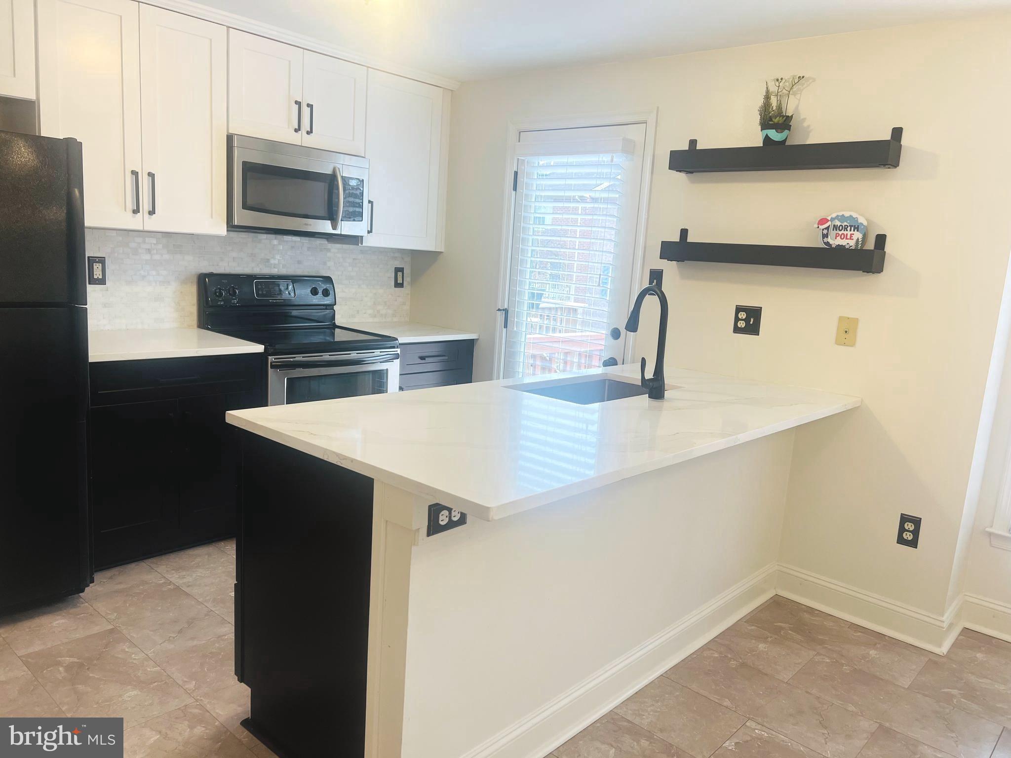 8024 Hollow Reed Court Frederick, MD 21701 - Photo 7 of 31 a kitchen with a sink a microwave a stove and refrigerator