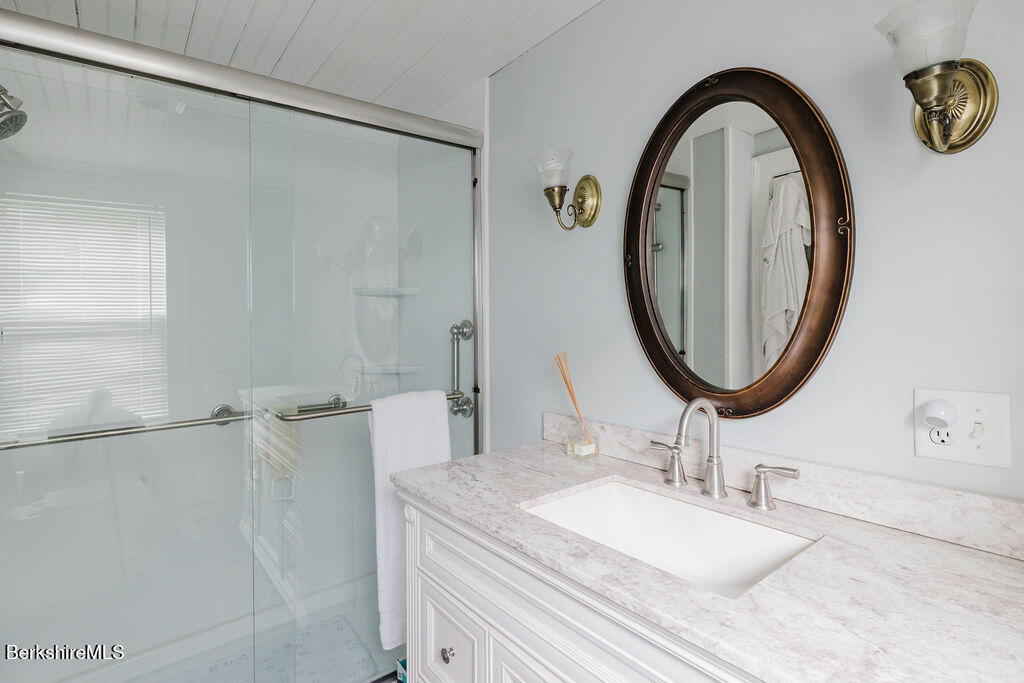168 Main Street Sheffield, MA 01257 - Photo 17 of 55 a bathroom with a granite countertop sink a mirror and a shower