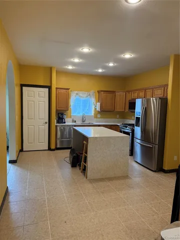 a kitchen with stainless steel appliances a refrigerator and a stove top oven