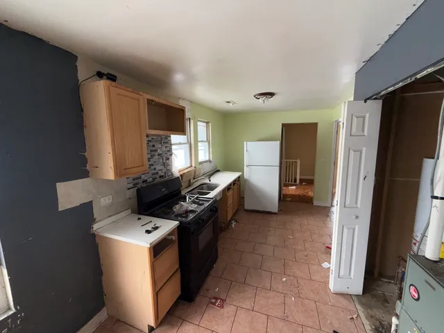 a kitchen with stainless steel appliances a refrigerator a sink a stove top oven a counter space and cabinets