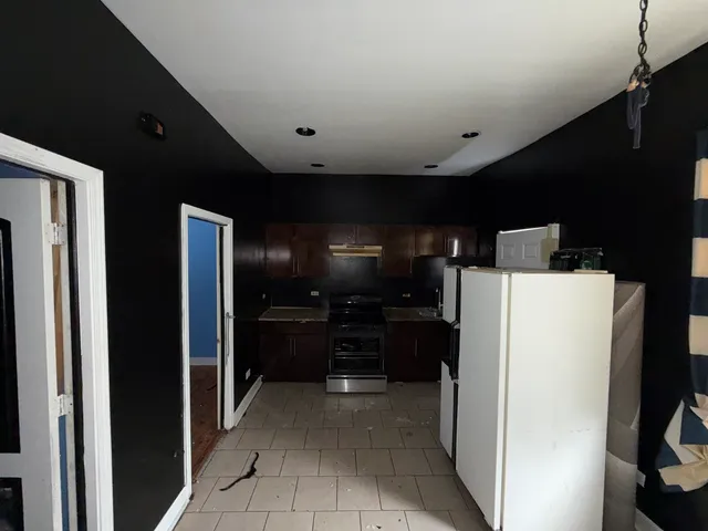 a kitchen with refrigerator and cabinets