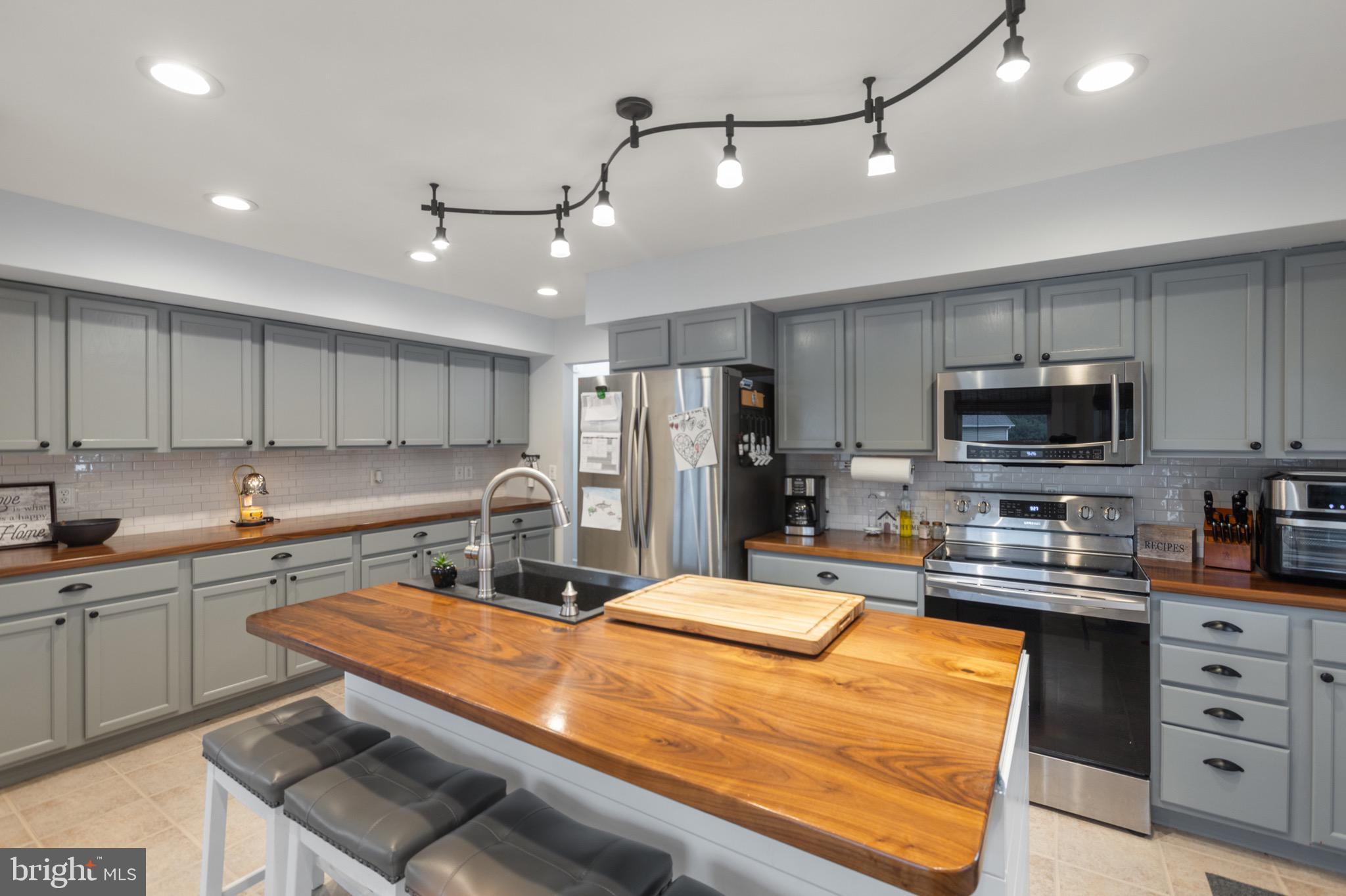 26179 Manor Way Georgetown, DE 19947 - Photo 13 of 87 a kitchen with stainless steel appliances kitchen island granite countertop a sink and cabinets