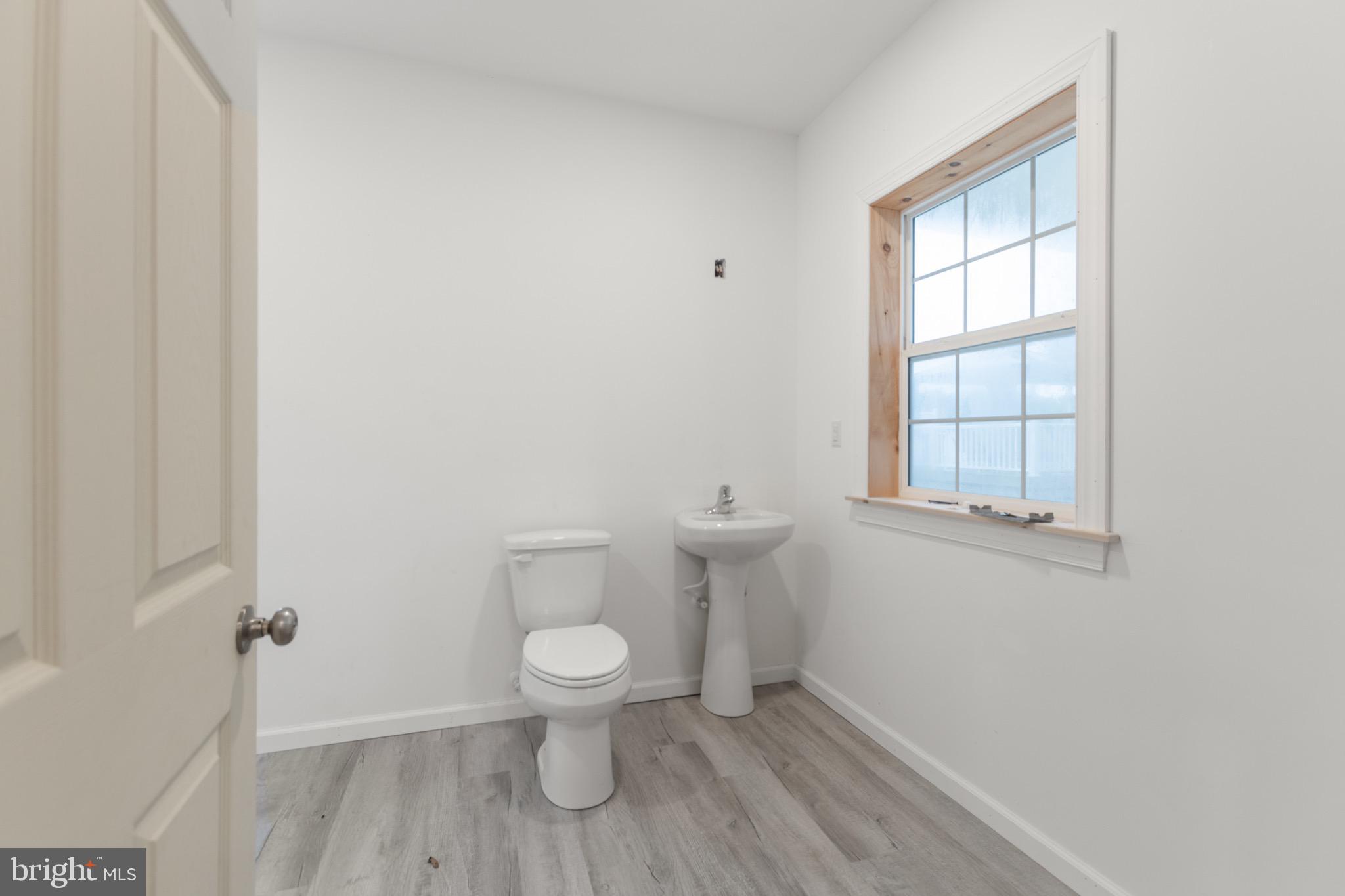 26179 Manor Way Georgetown, DE 19947 - Photo 36 of 87 a white toilet sitting in a bathroom next to a window