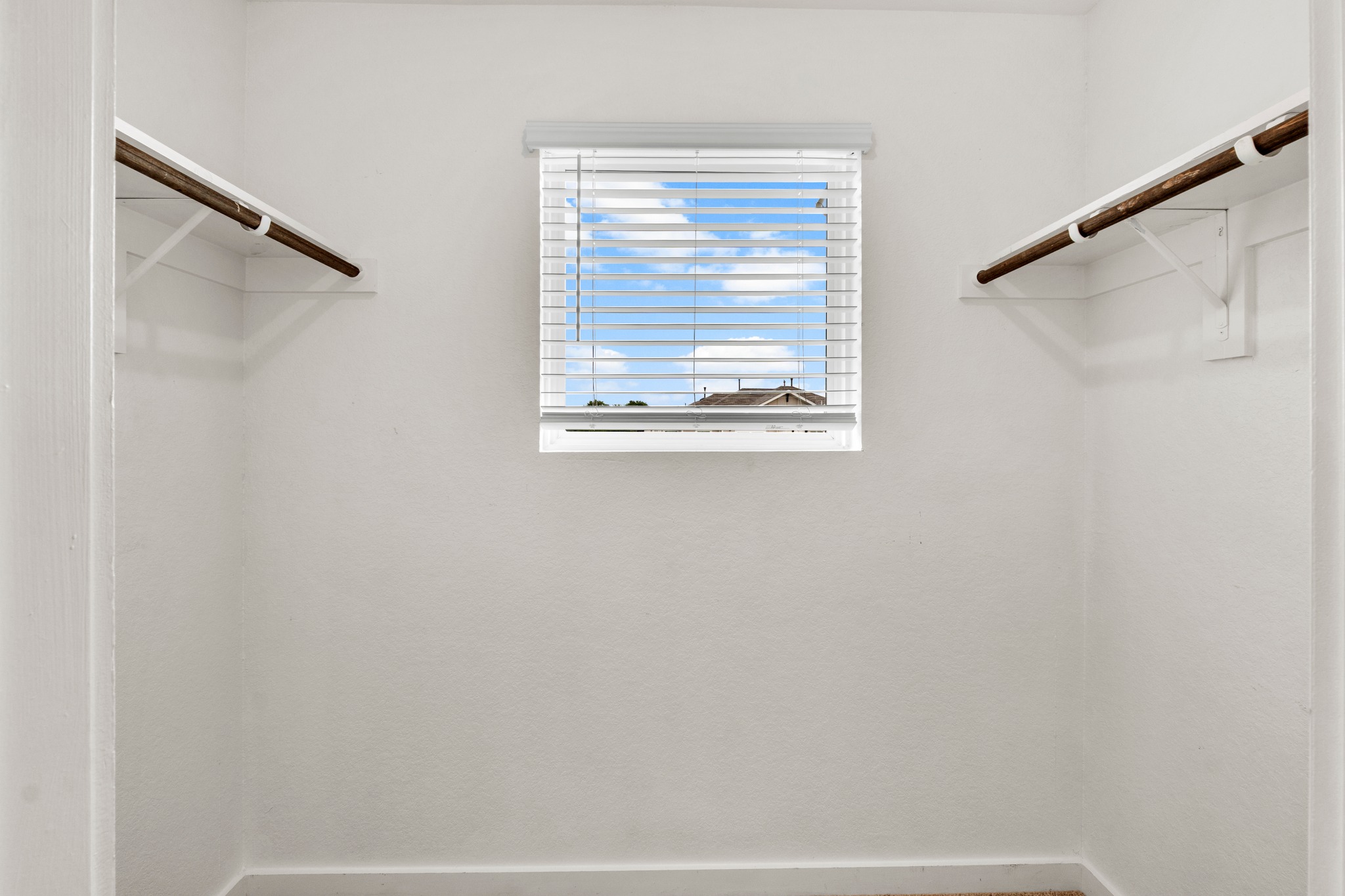 2251 Rocoso Trail Leander, TX 78641 - Photo 25 of 34 A window brings natural light into this functional closet space featuring built-in hanging rods.