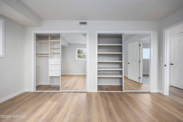 a view of an empty room with cabinet and a window
