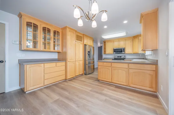 a kitchen with stainless steel appliances granite countertop a stove a sink and a refrigerator