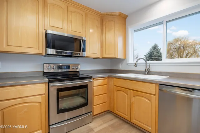 a kitchen with cabinets stainless steel appliances a sink and a stove