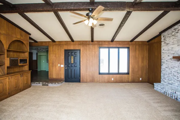 a view of a livingroom with a ceiling fan and window