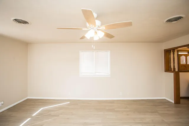 an empty room with closet and a chandelier fan