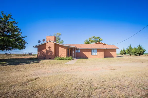a big house with a big yard plants and large trees