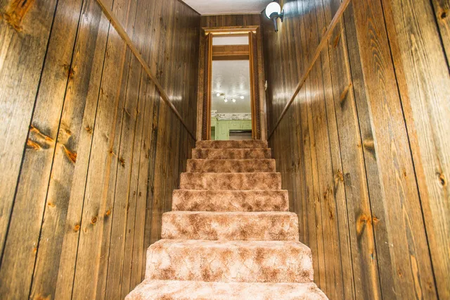 a view of staircase with railing and white walls