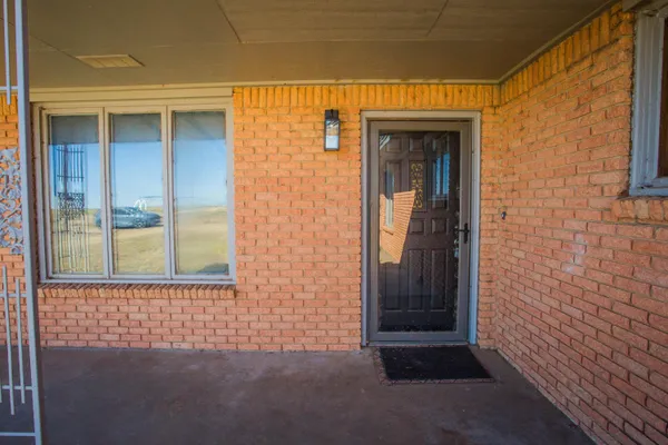 a view of an empty room with window and chandelier fan
