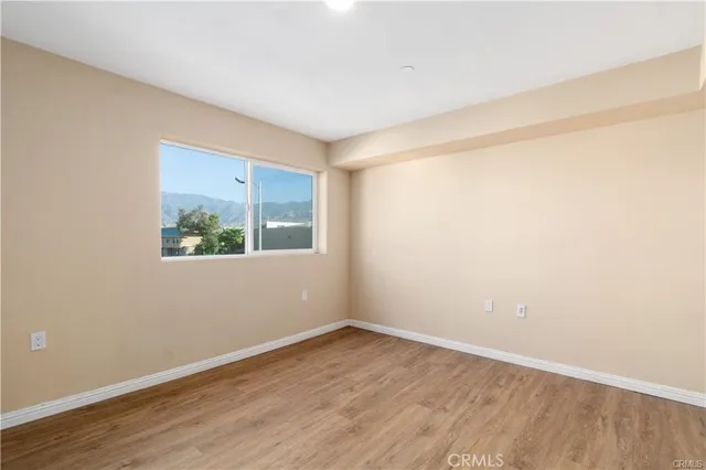 an empty room with wooden floor and window