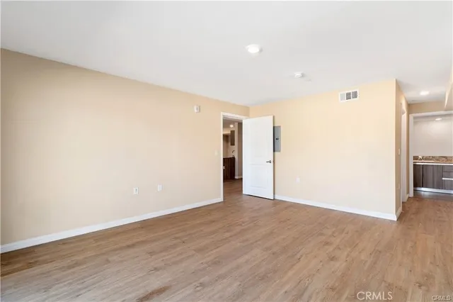 a view of an empty room with wooden floor