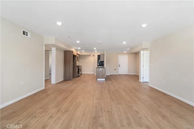 a view of an empty room with wooden floor