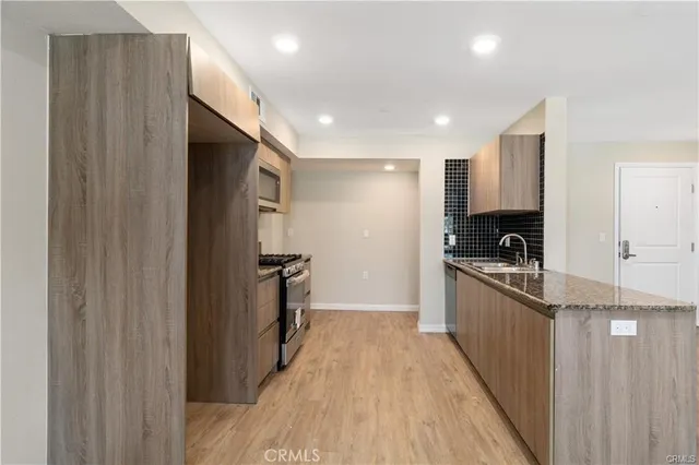 a kitchen with granite countertop a refrigerator and a sink