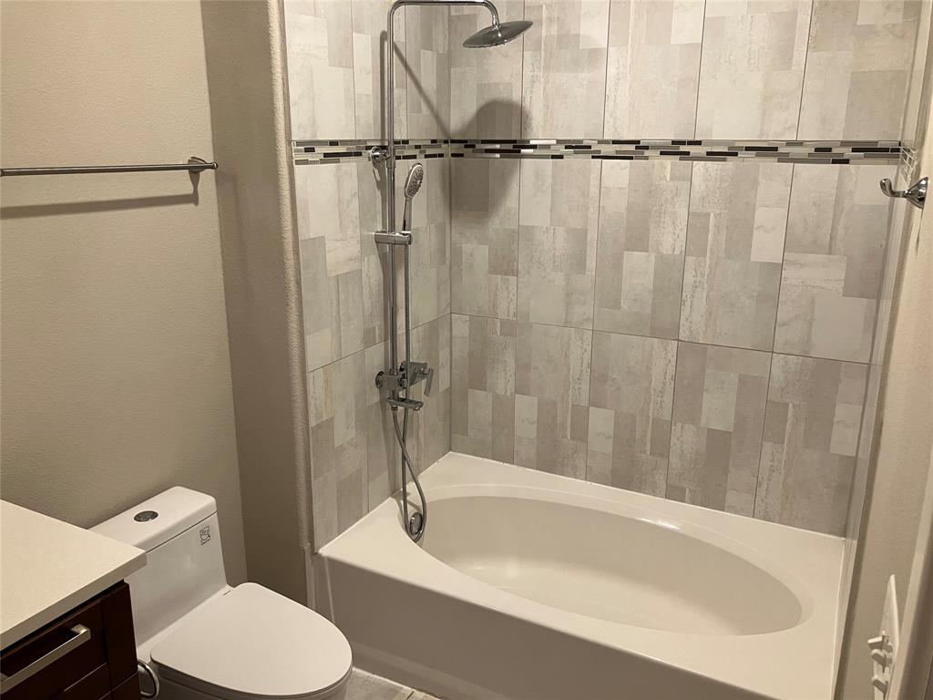 1220 West Trinity Mills Road, Unit 5009 Carrollton, TX 75006 - Photo 16 of 25 a bathroom with a toilet and a bathtub