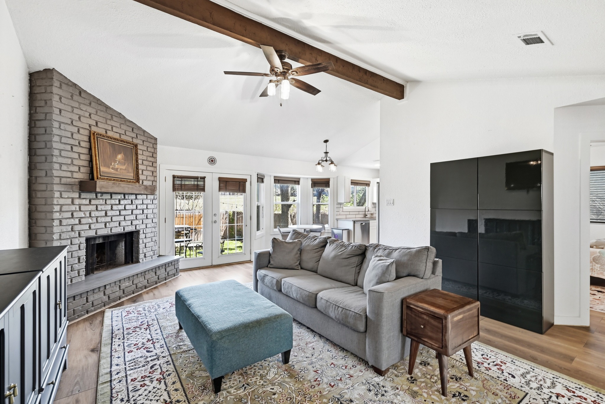 5610 Fence Row Austin, TX 78744 - Photo 2 of 26 Light and open living room with a brick fireplace and wood ceiling beams.