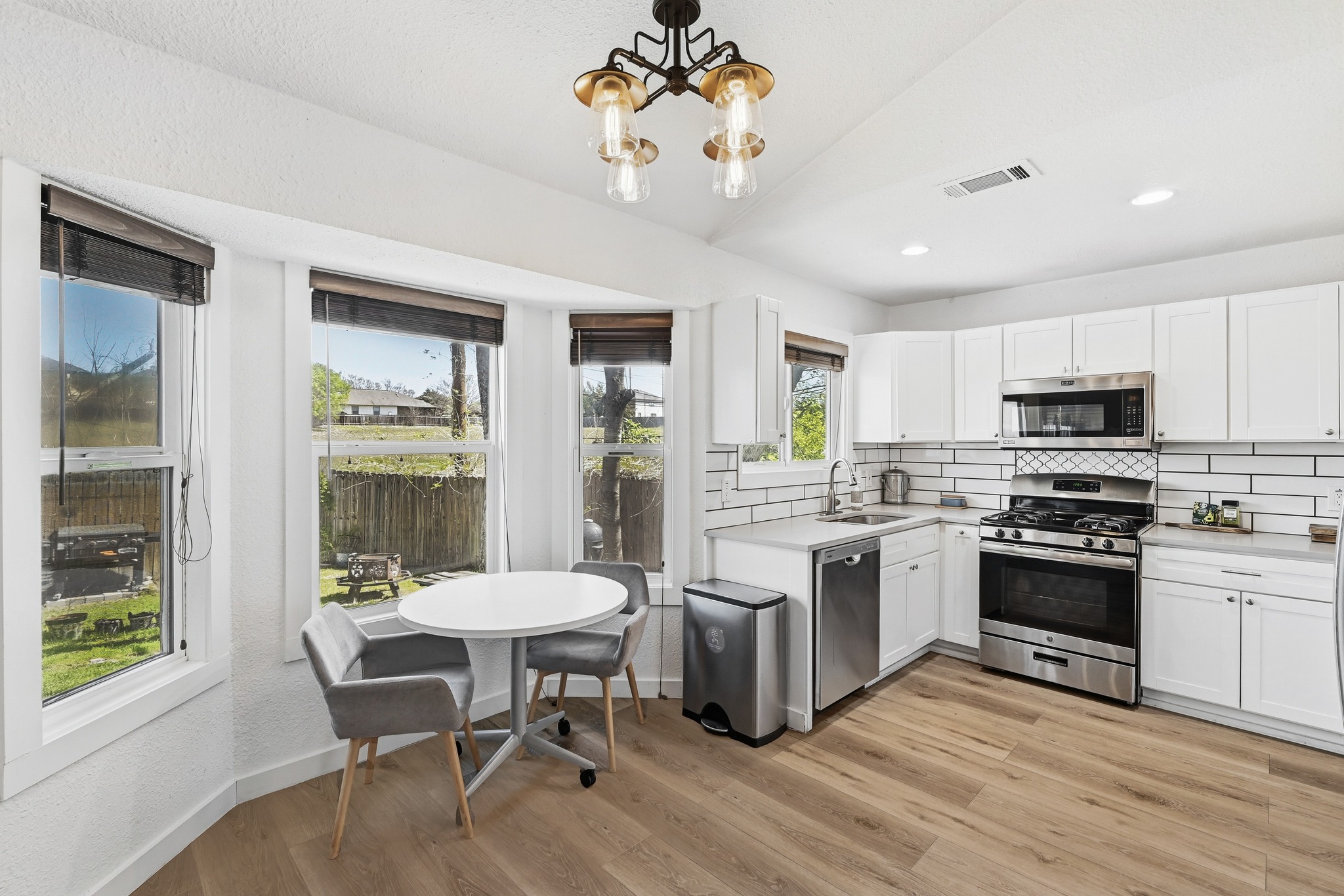 5610 Fence Row Austin, TX 78744 - Photo 4 of 26 Check out this Kitchen with stainless steel appliances, white cabinets, tasteful backsplash, light flooring, and an eat in breakfast nook. The bay window lets in so much light.