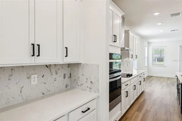 a kitchen with granite countertop white cabinets and white appliances