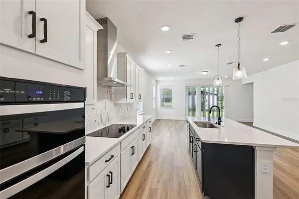 a kitchen with kitchen island a counter top space a sink stainless steel appliances and cabinets