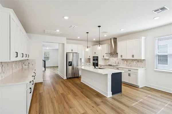 a kitchen with kitchen island a sink stove and refrigerator