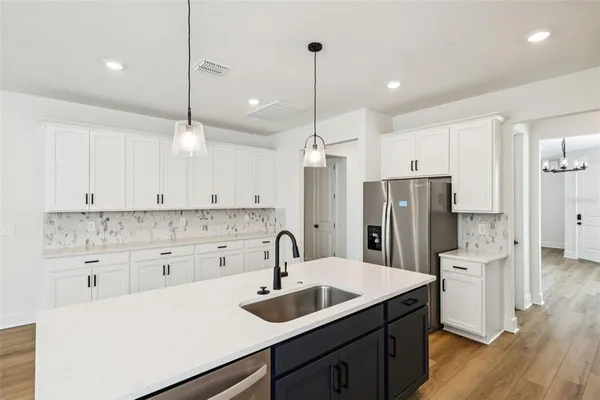a kitchen with a sink a center island a stove and a wooden floor