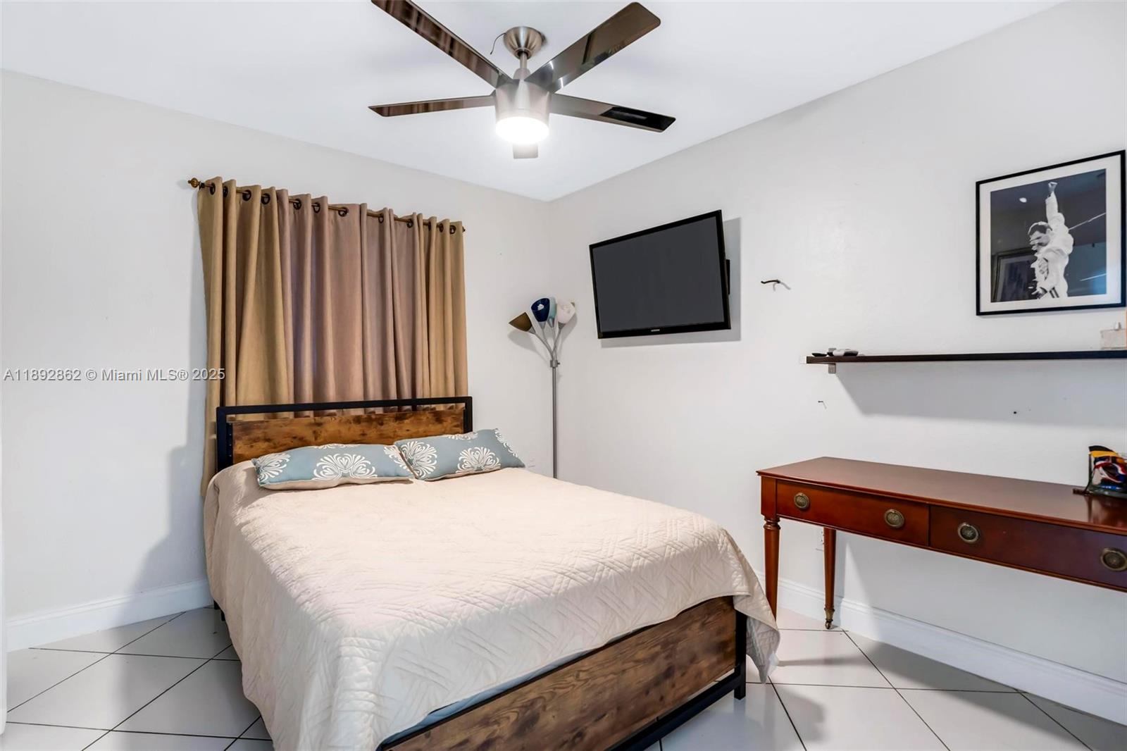 8111 Southwest 205th Street Cutler Bay, FL 33189 - Photo 13 of 51 a bedroom with a bed a flat screen tv and a chandelier