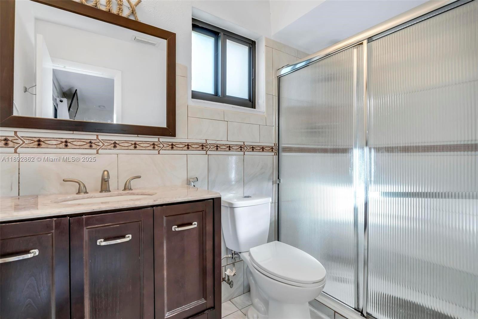 8111 Southwest 205th Street Cutler Bay, FL 33189 - Photo 16 of 51 a bathroom with a toilet sink and mirror