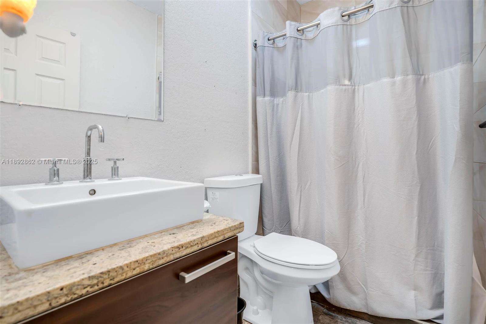 8111 Southwest 205th Street Cutler Bay, FL 33189 - Photo 22 of 51 a bathroom with a sink a toilet and shower curtain