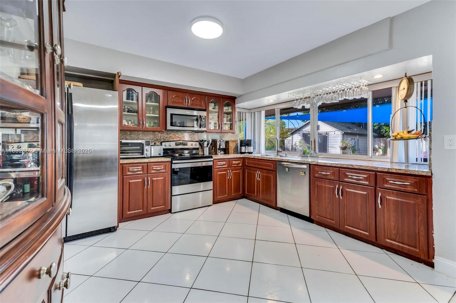 8111 Southwest 205th Street Cutler Bay, FL 33189 - Photo 10 of 51 a kitchen with stainless steel appliances granite countertop a stove sink and cabinets
