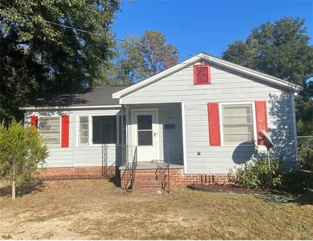 a view of a house with a yard and potted plants