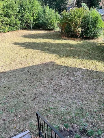 a view of a yard with a wooden fence