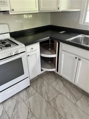 a stove top oven sitting inside of a kitchen