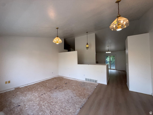 838 East Mountain Road Logan, UT 84321 - Photo 5 of 37 Expansive interior space featuring a partial wall, multiple pendant light fixtures, and a combination of subfloor and wood-finish flooring
