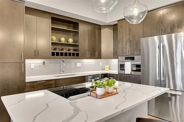 a kitchen with stainless steel appliances a sink and a refrigerator
