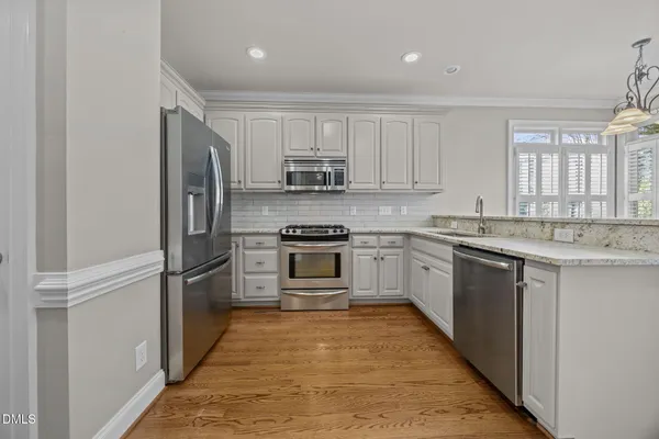 a kitchen with cabinets stainless steel appliances and window
